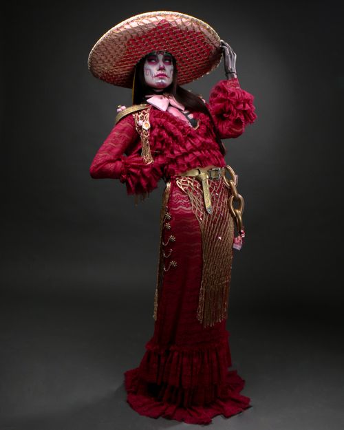 Free Woman in elaborate Mexican-inspired costume posing with a dramatic flair. Stock Photo