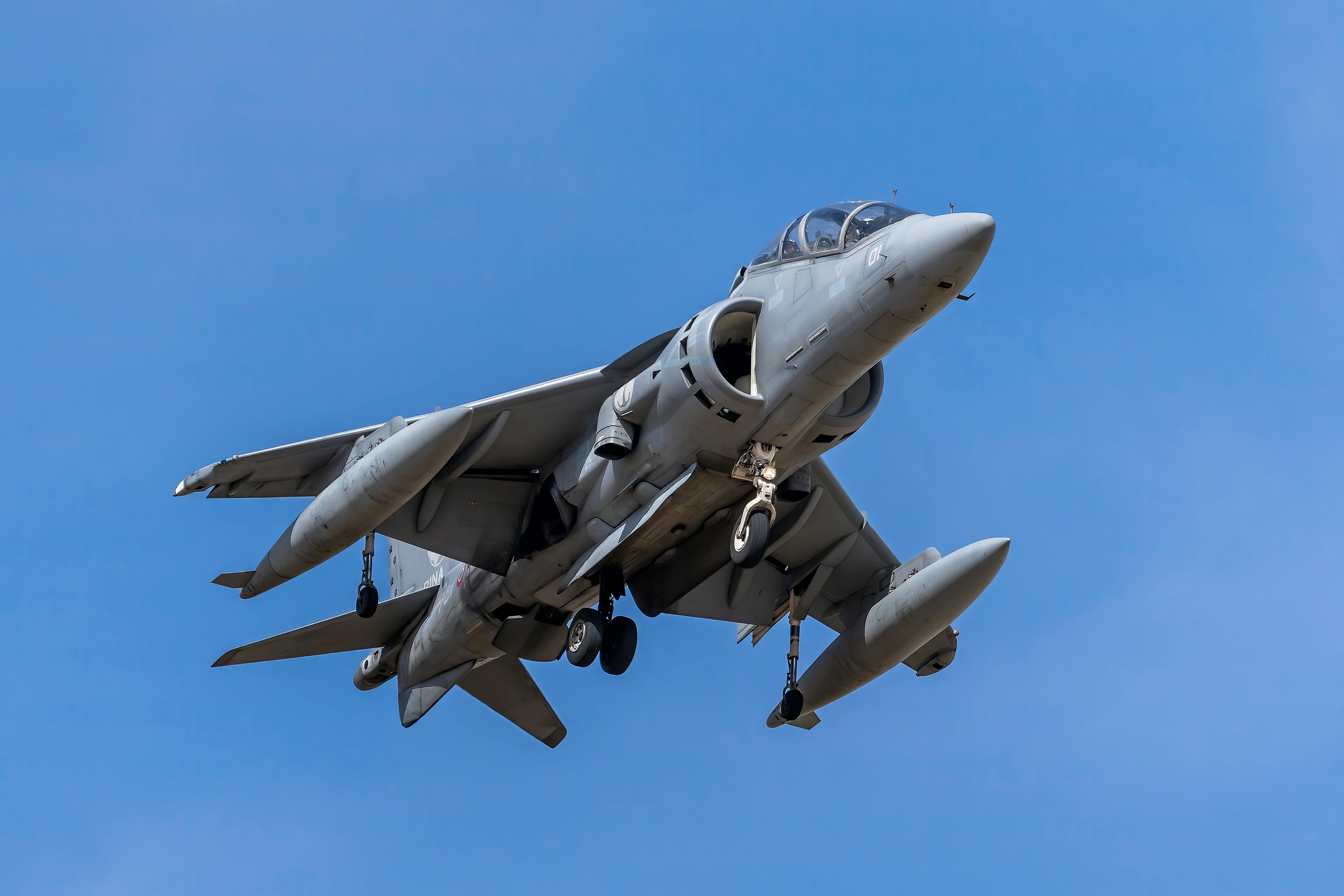 A dynamic capture of a military jet in flight showcasing power and speed against a clear blue sky.