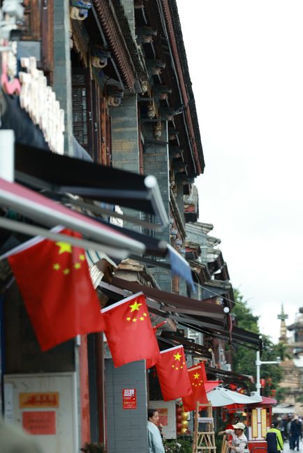 Fotomural Calle histórica de China adornada con banderas nacionales y arquitectura tradicional china.