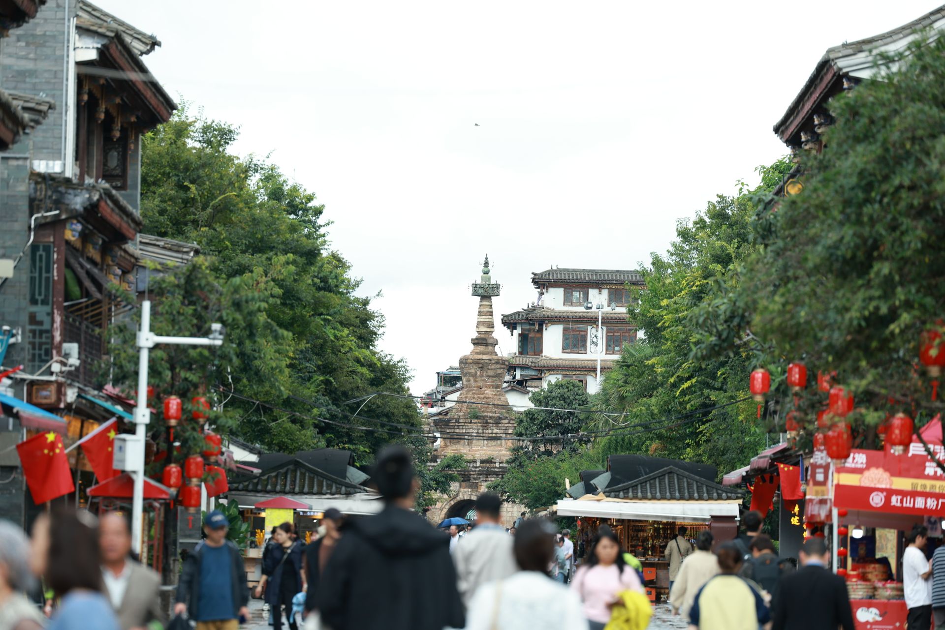 Lively street scene in a Chinese marketplace with red lanterns and diverse crowd.