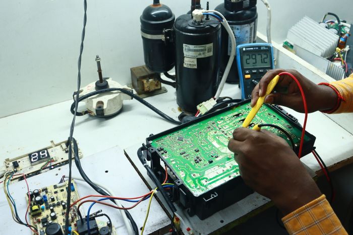 Technician repairing an AC circuit board