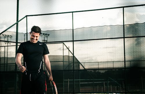 免費 男子身穿黑色耐克dri Fit襯衫拿著網球拍 圖庫相片