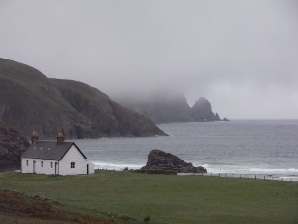 Misty Scottish coastal landscape with cottage before heat pump installation