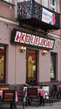 A cozy cafe in Kielce, Poland, featuring outdoor seating and decorative facade.