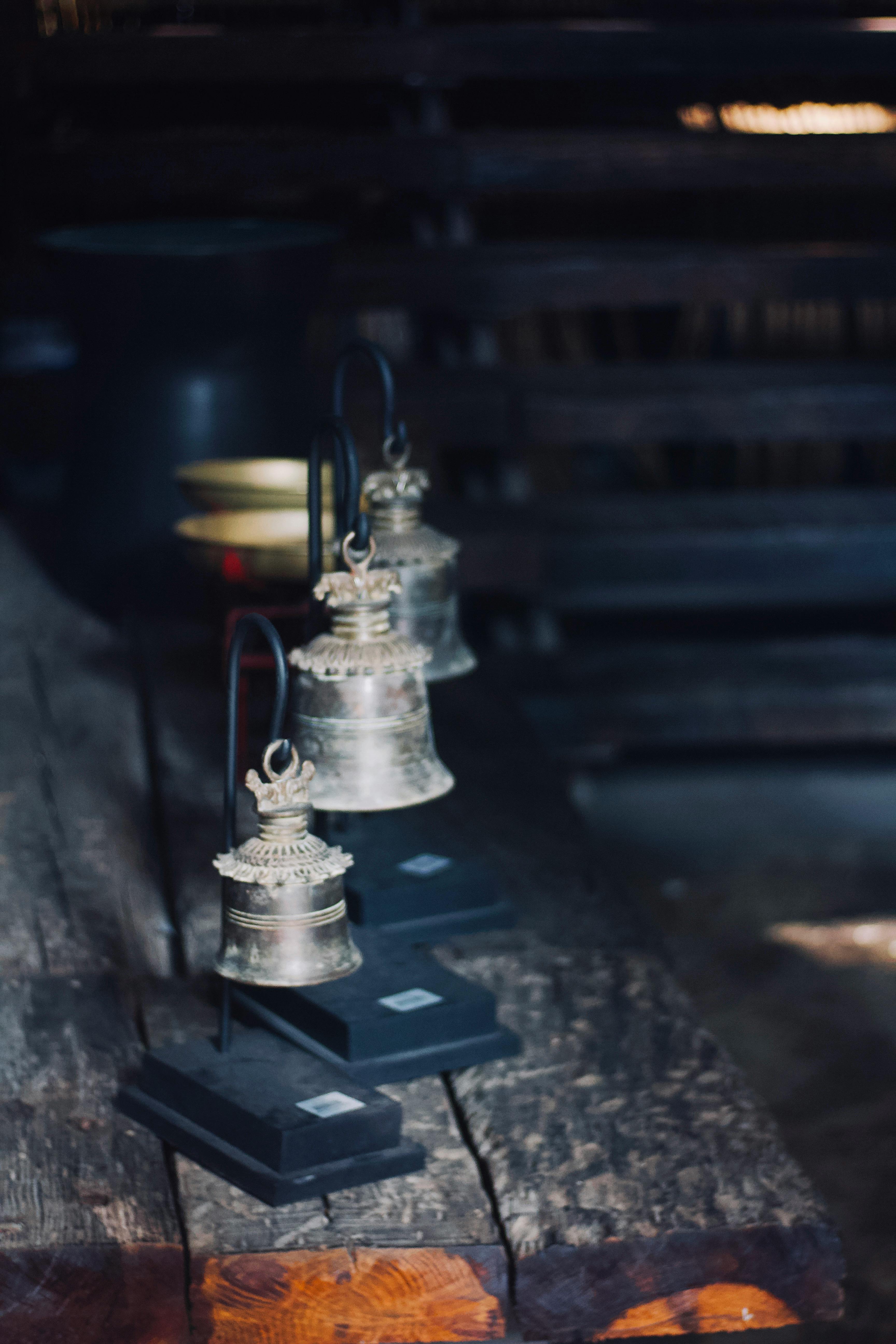 Gratuit Charmantes cloches rustiques placées sur une table en bois, capturant une sensation antique avec un éclairage tamisé. Photos