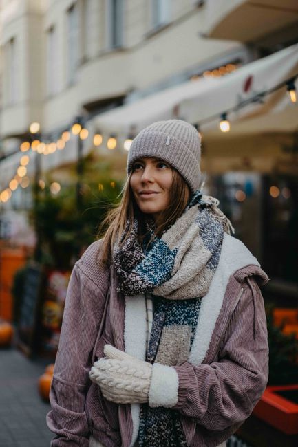 Relaxed woman in autumn attire walking outdoors, enjoying the city atmosphere.