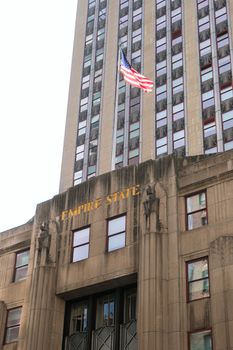 Close-up of the Empire State Building facade with American flag.