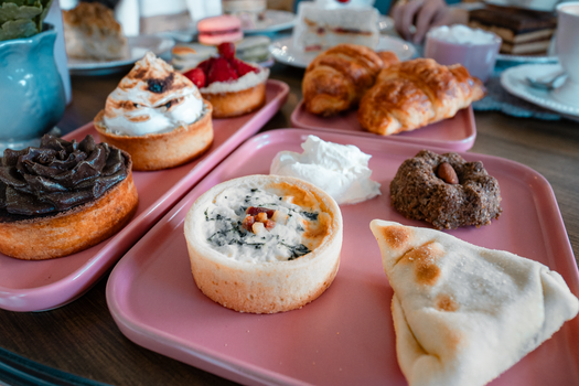 A delightful assortment of pastries displayed on pink trays, perfect for brunch or tea time.