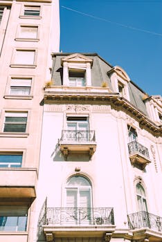 Striking European-style building with ornate balconies against a bright blue sky.