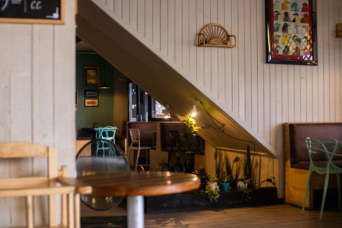 Cozy café seating area with wooden chairs and ambient warm lighting.