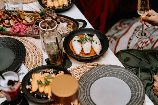 Explore this appetizing dinner spread featuring gourmet dishes and drinks in a cozy outdoor setting.