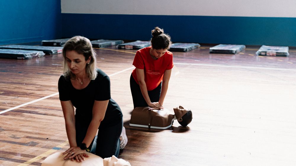 Adults practising CPR during first aid training