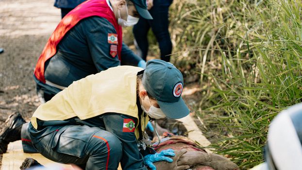 Photo by Aleson Padilha Emergency responders perform a life-saving simulation outdoors, demonstrating teamwork and first aid skills.