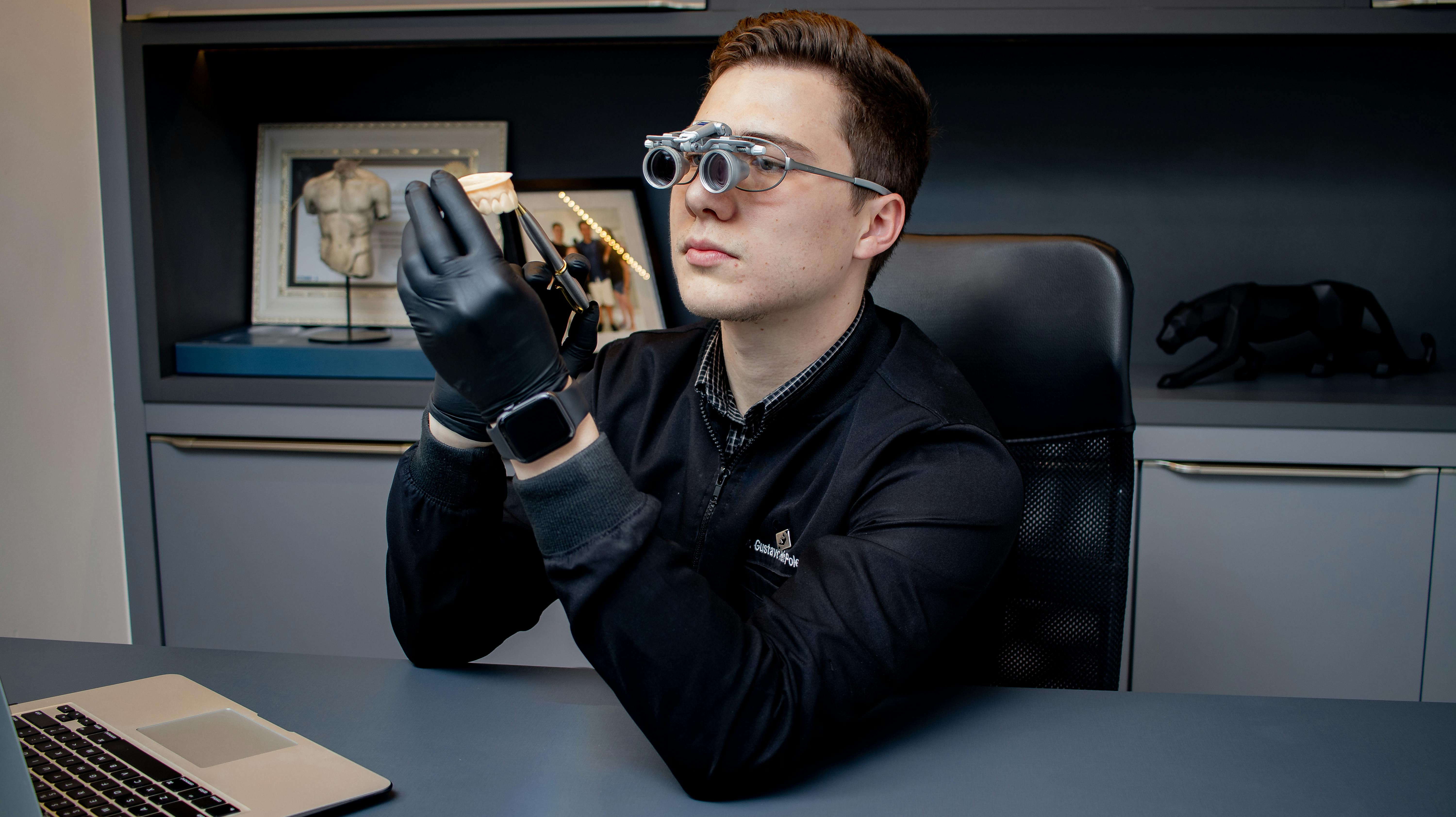 Gratis Il dentista utilizza lenti di ingrandimento per esaminare le impronte dentali in uno studio moderno, dimostrando così l'efficacia delle cure odontoiatriche professionali. Foto a disposizione