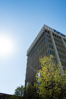 Urban skyscraper with blue sky in Grand Rapids, Michigan, captured in sunlight with modern architectural design.