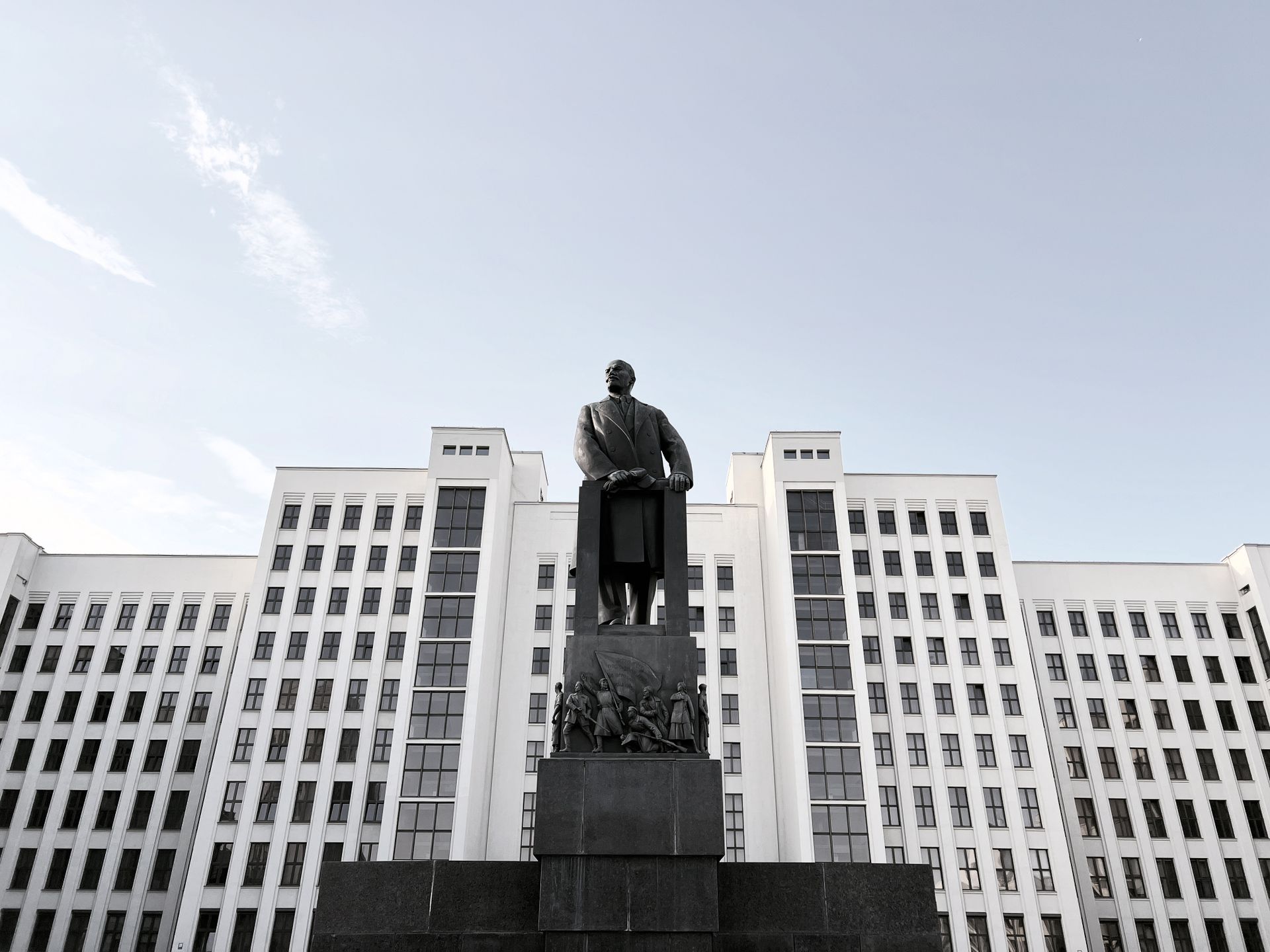Monument before a grand government building under clear skies.