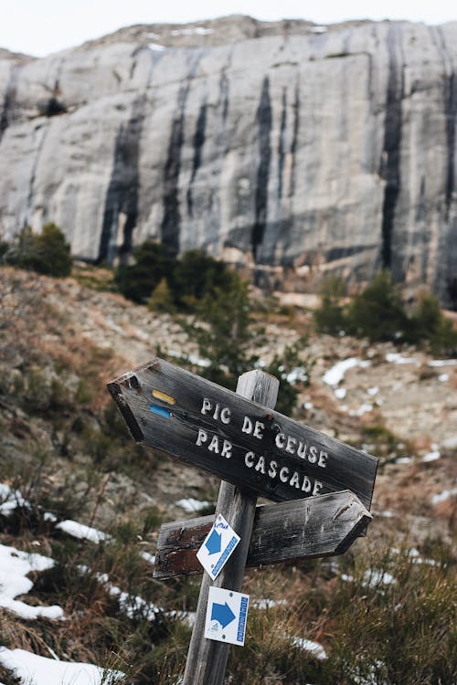 Gray Wooden Sign Beside Mountian