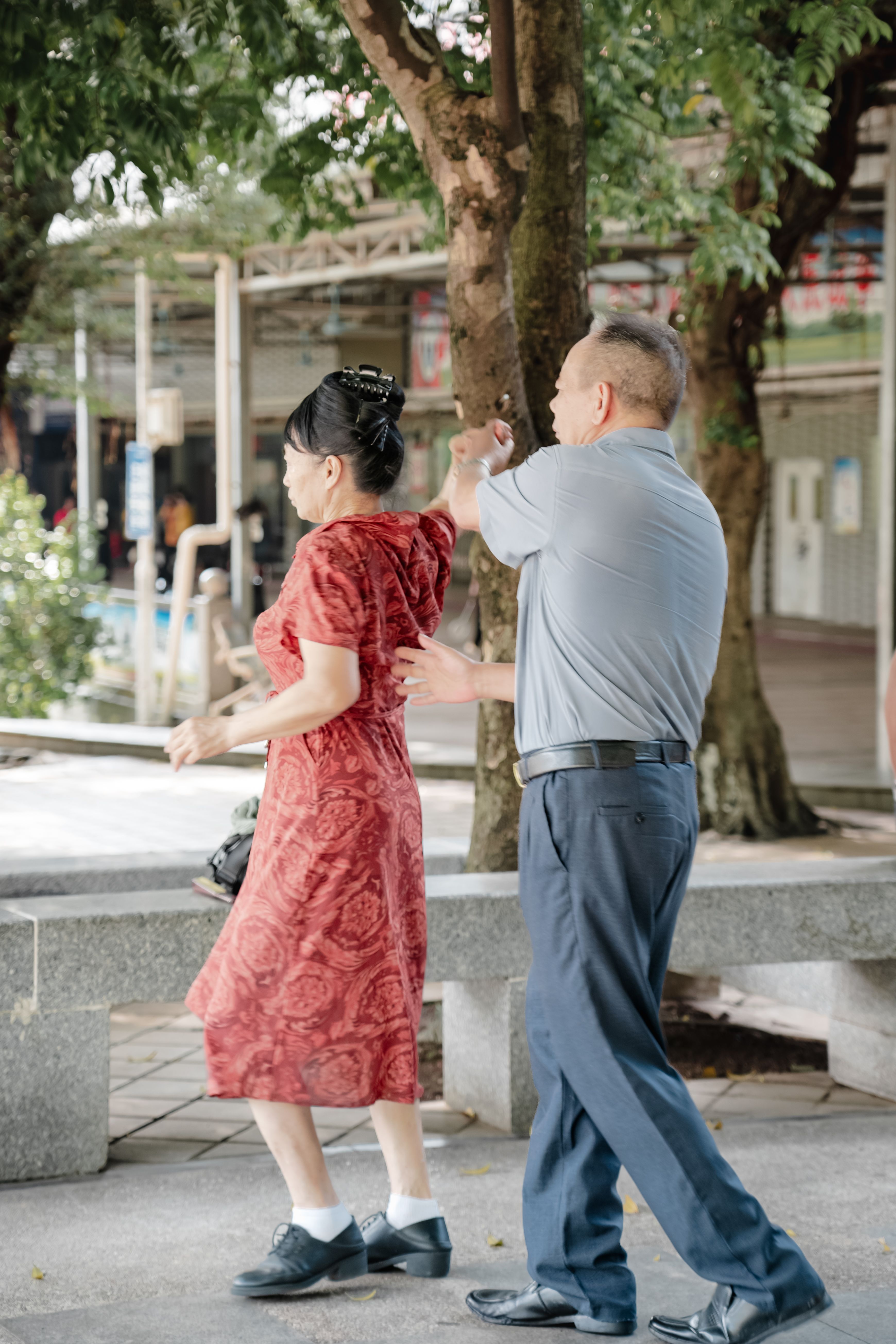 Joyful elderly couple dancing gracefully in a serene park setting, embracing life and happiness.