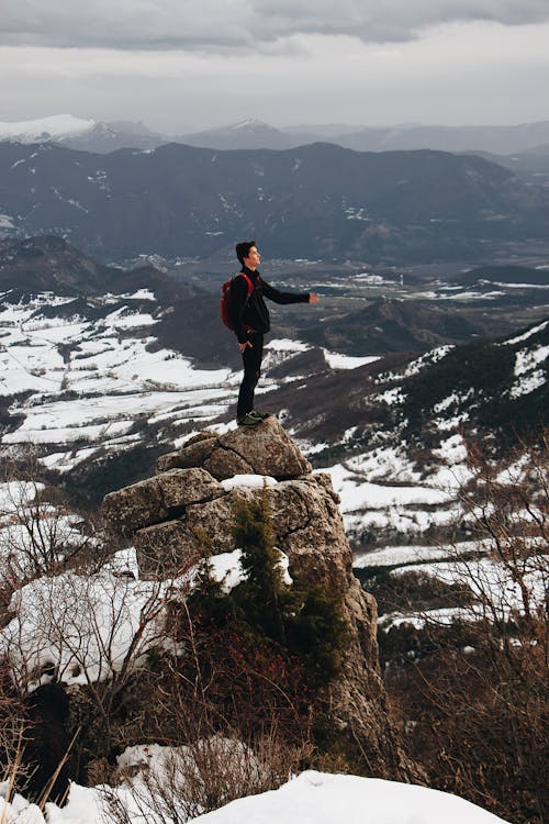 Man Standing on Top of Mountain