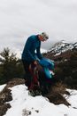 男子在雪山徒步冒险时调整了背包