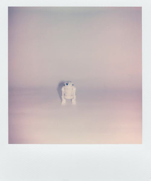 Foto Polaroid De Um Pequeno Robô De Brinquedo Em Fundo Branco