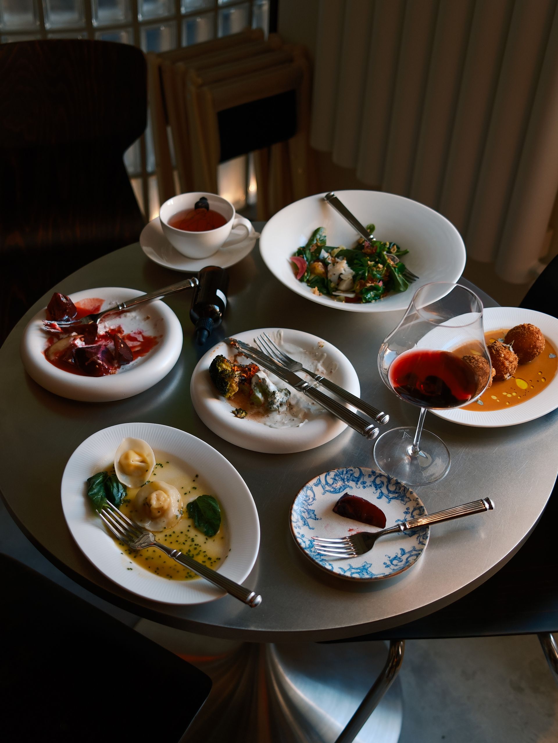 Gourmet fine dining spread with plated dishes and wine on an elegant table