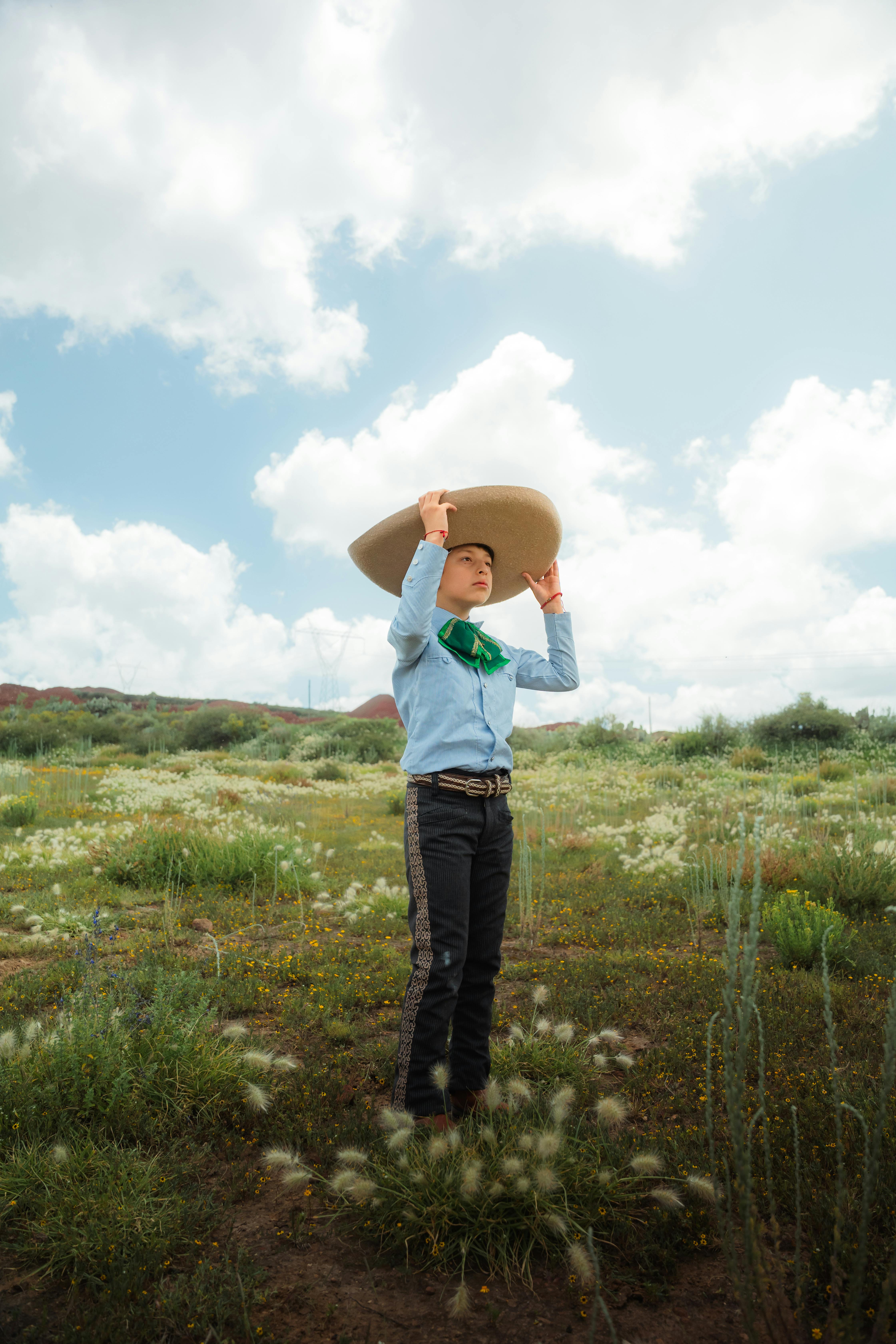 Mid-adult person wearing a sombrero, standing in a lush field in Hidalgo, Mexico