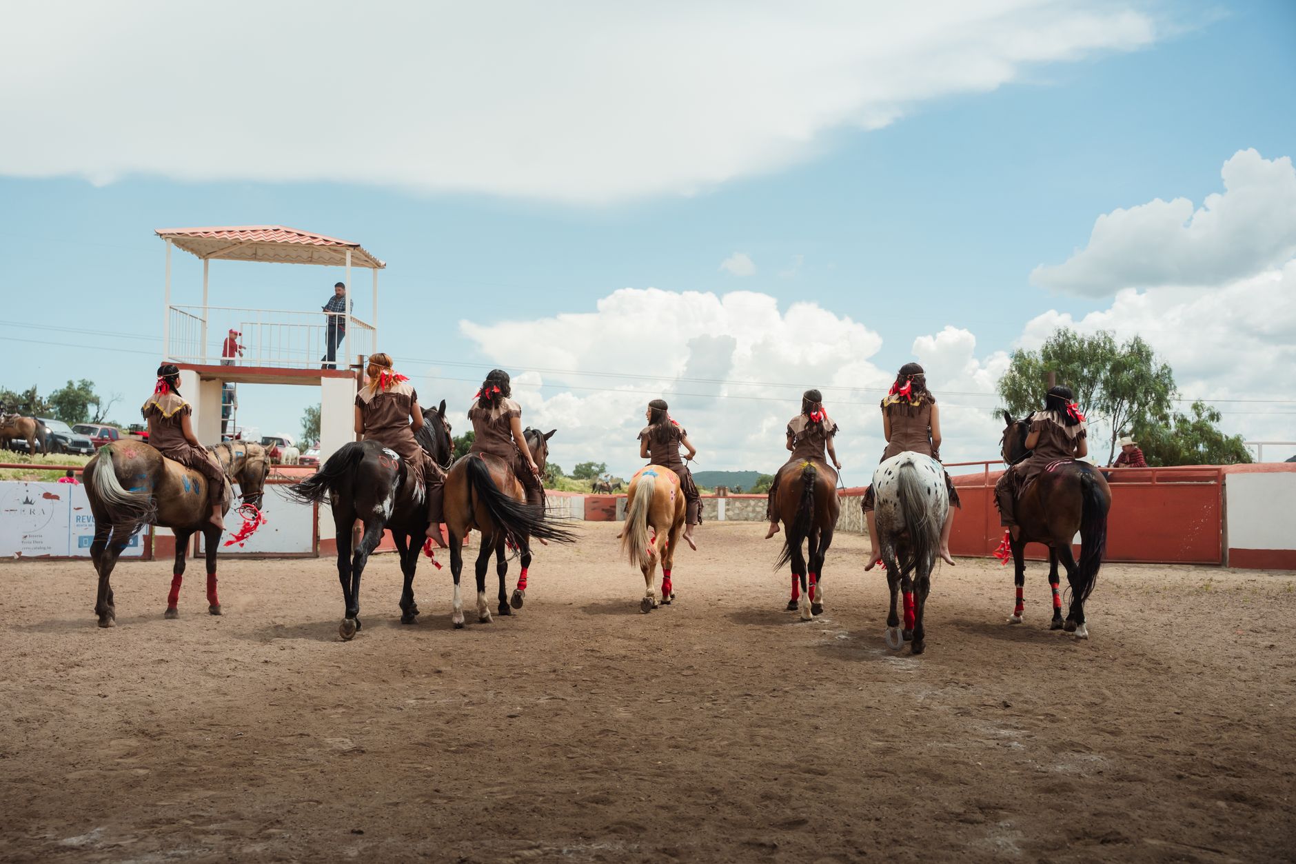 Spectators leaving a rural arena as sheriff vehicles secure the entrance during an evening investigation