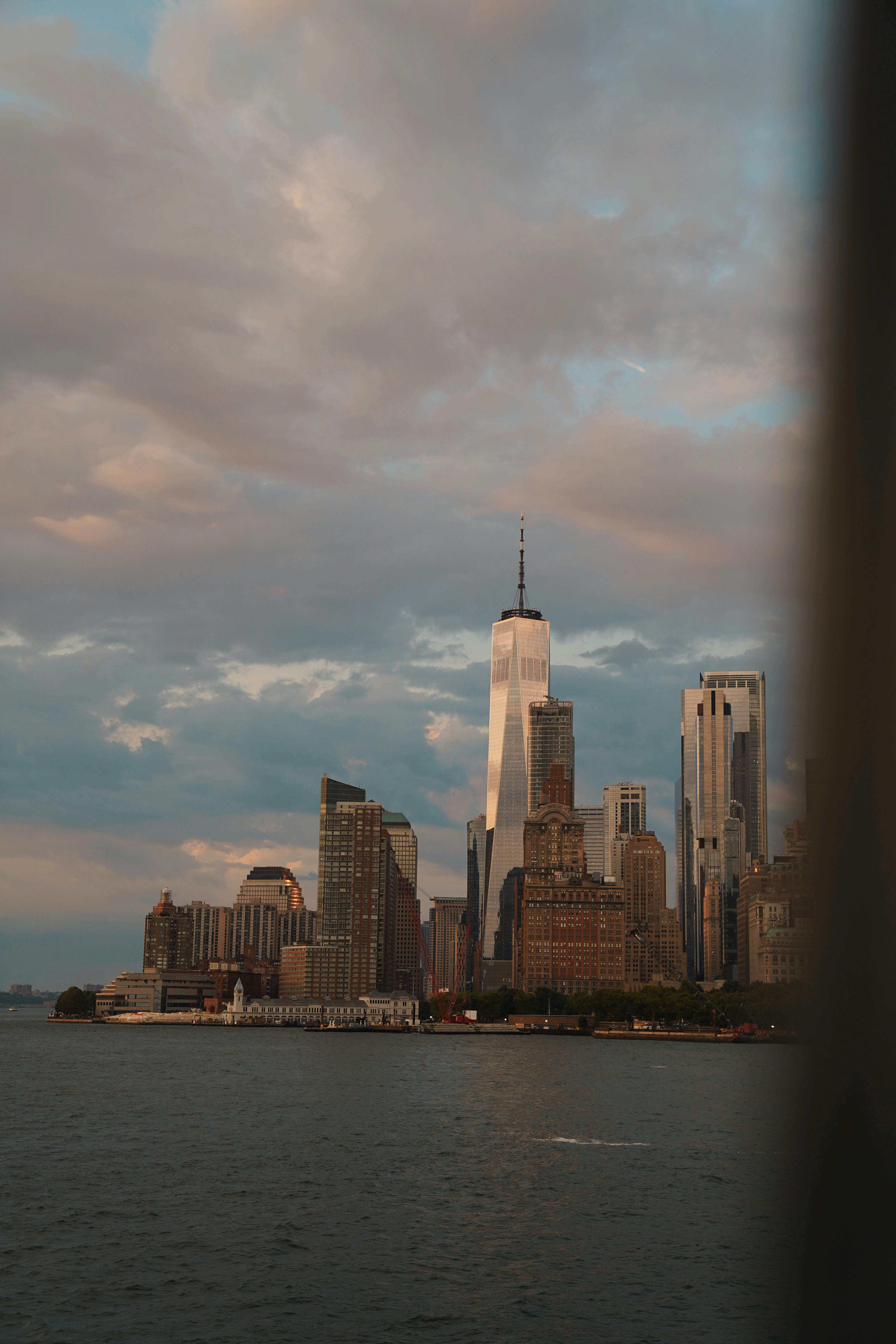 Capture of New York City's skyline featuring One World Trade Center under a dramatic sky.