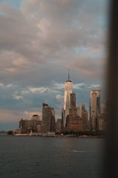Capture of New York City's skyline featuring One World Trade Center under a dramatic sky.