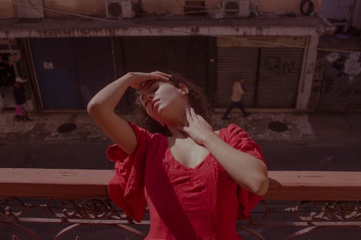 Woman in a red dress posing on a balcony in Rio de Janeiro, Brazil.