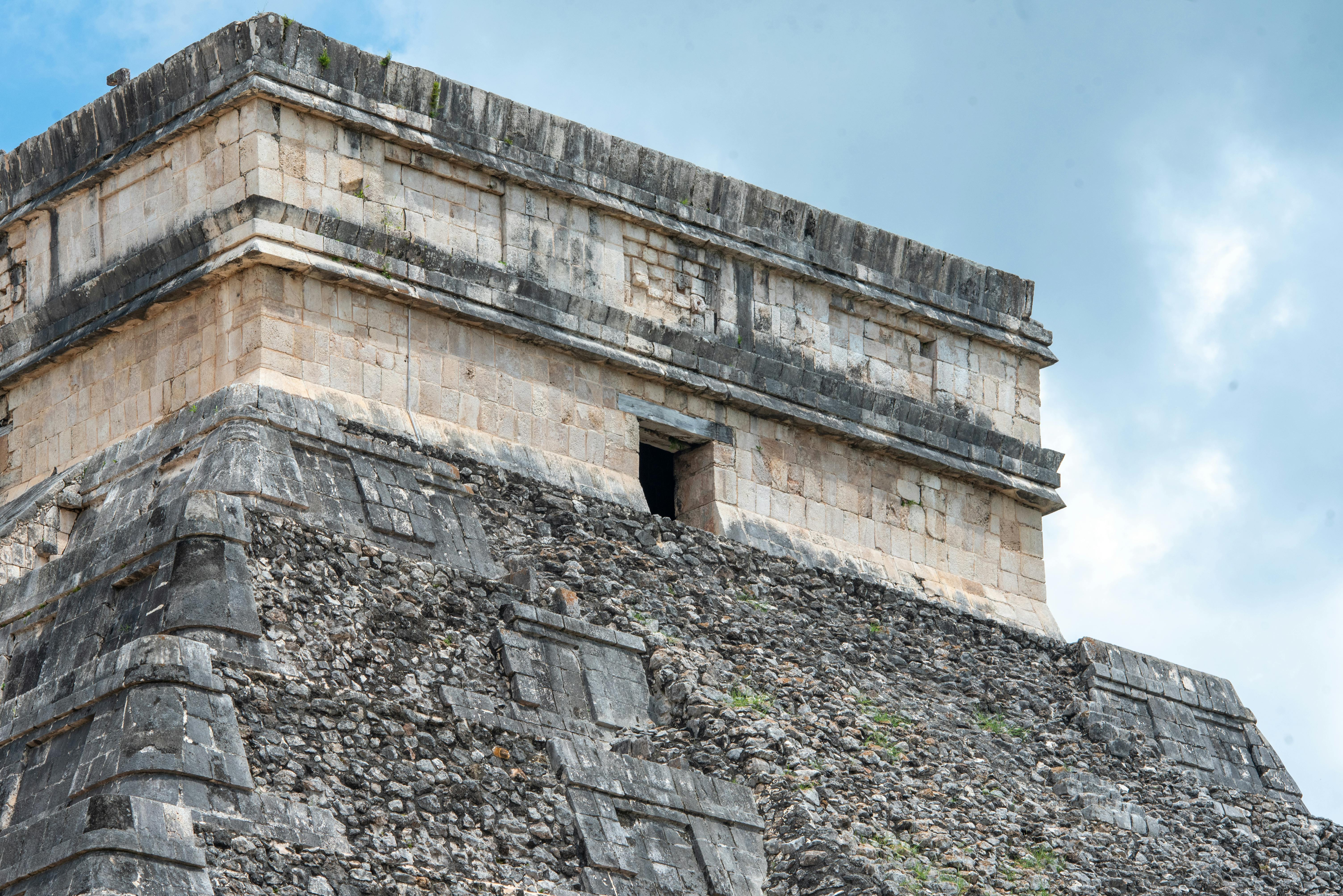 maya archaeology tour best practices for travel agents - Close-up of the ancient Mayan pyramid at Chichén Itzá, showcasing detailed stonework against a blue sky.