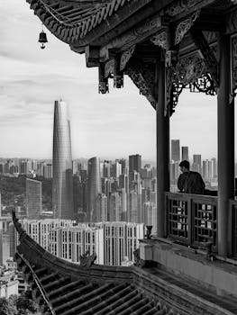 A blend of traditional Chinese architecture and modern cityscape in black and white.