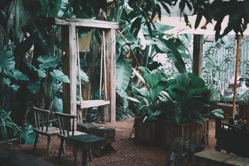 Free Natural garden scene with wooden swing and lush greenery, perfect for relaxation. Stock Photo