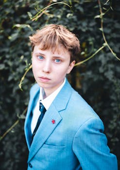 Teenager with blue eyes in a blue suit posing outdoors in Berlin.