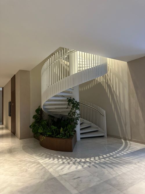 Free A stunning indoor spiral staircase with plants in a modern architectural setting, offering elegance and style. Stock Photo