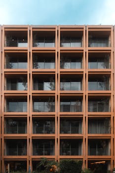 Contemporary apartment facade in Mexico City with symmetrical design and warm tones.