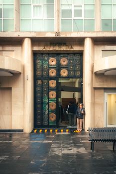 Elegant entrance of Avenida Building in Mexico City with pedestrian.