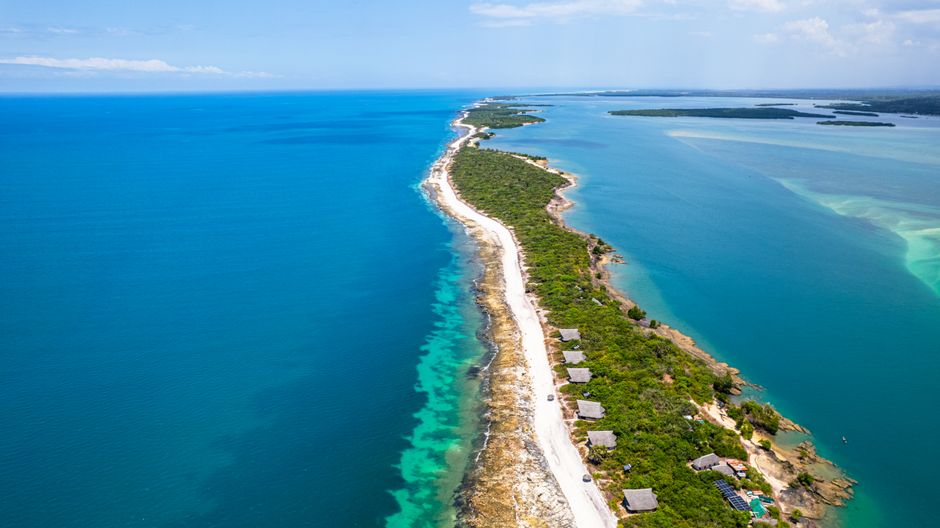 Discover the breathtaking aerial view of an island bordered by crystal blue waters ideal for exploration.