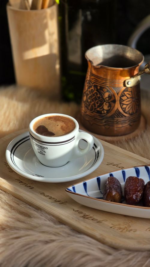 Free A cozy setting with Arabic coffee, dates, and traditional copper pot. Stock Photo