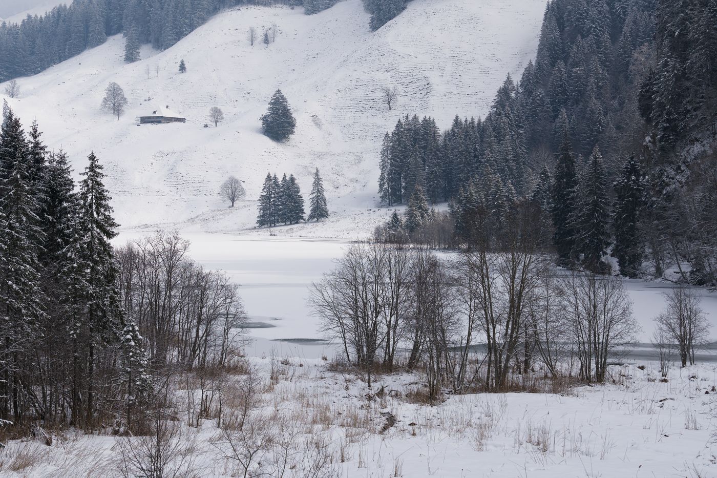 Snow-covered hills and a frozen lake in the Swiss Alps in winter
