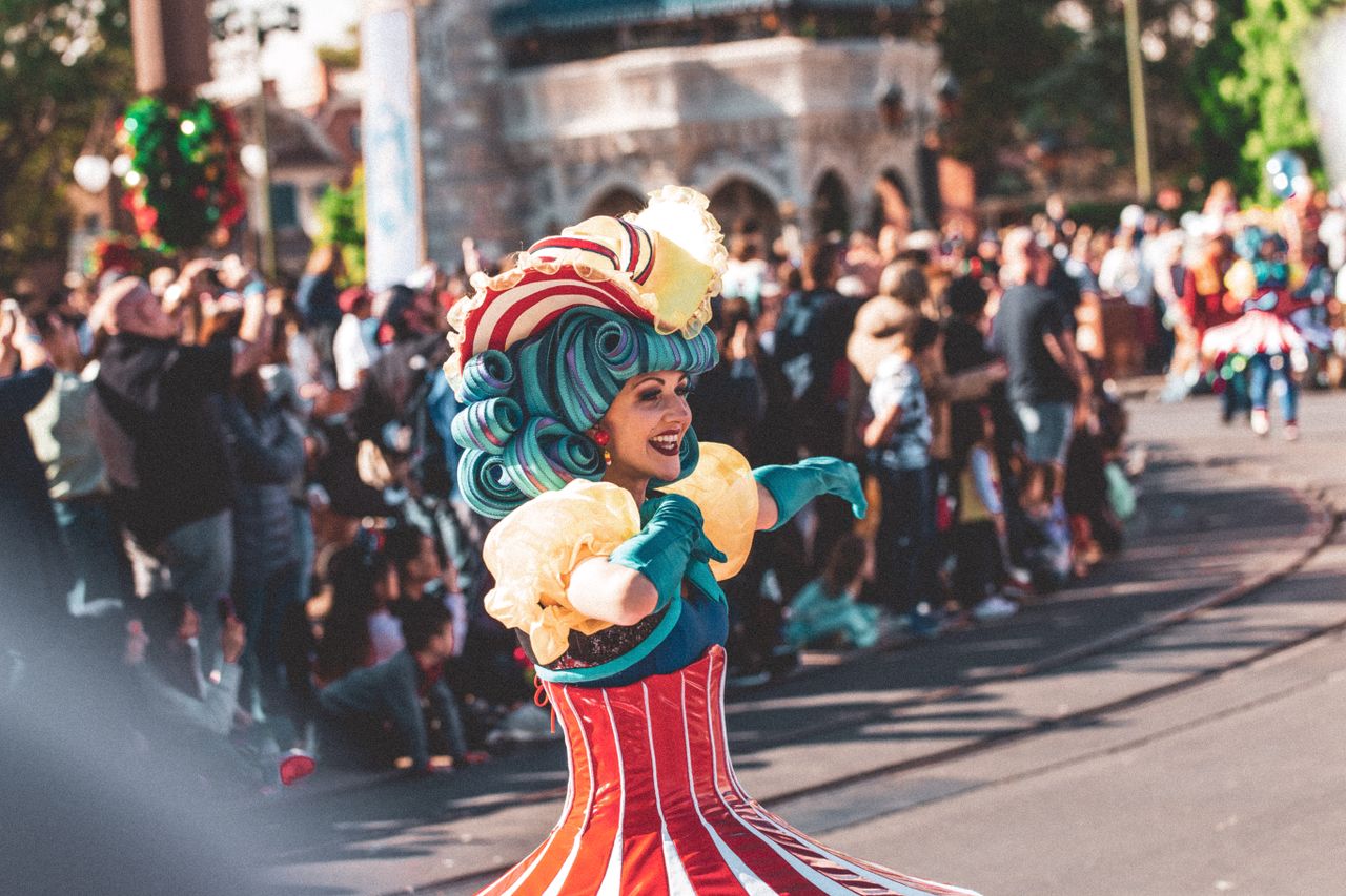 a lively performer in colorful costume entertains the crowd at a festi