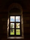 透过历史悠久的拱形窗户，阳光投射出阴影，欣赏自然景观