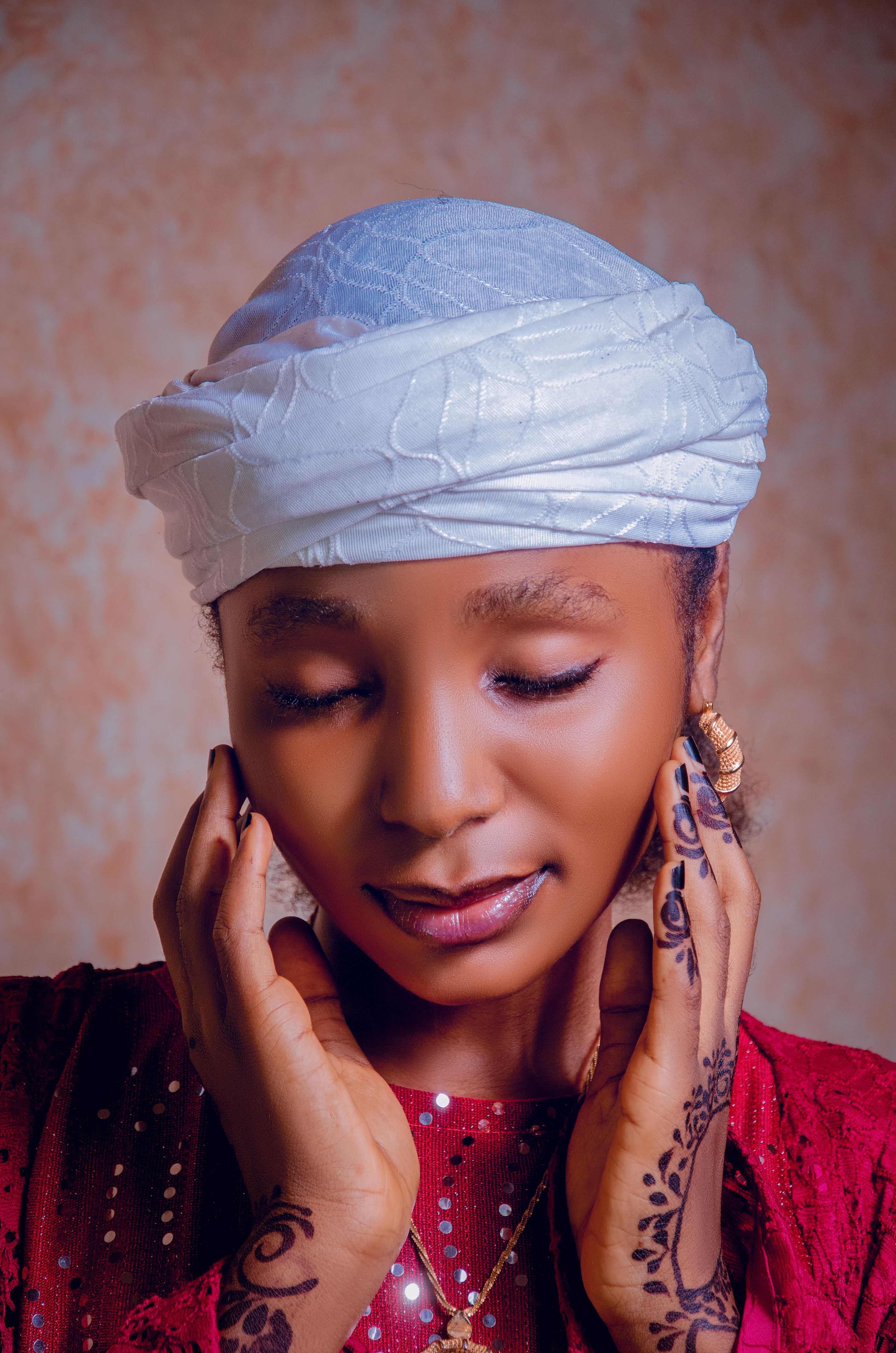 Portrait of an elegant African woman with henna designs, wearing traditional attire in Bauchi, Nigeria.