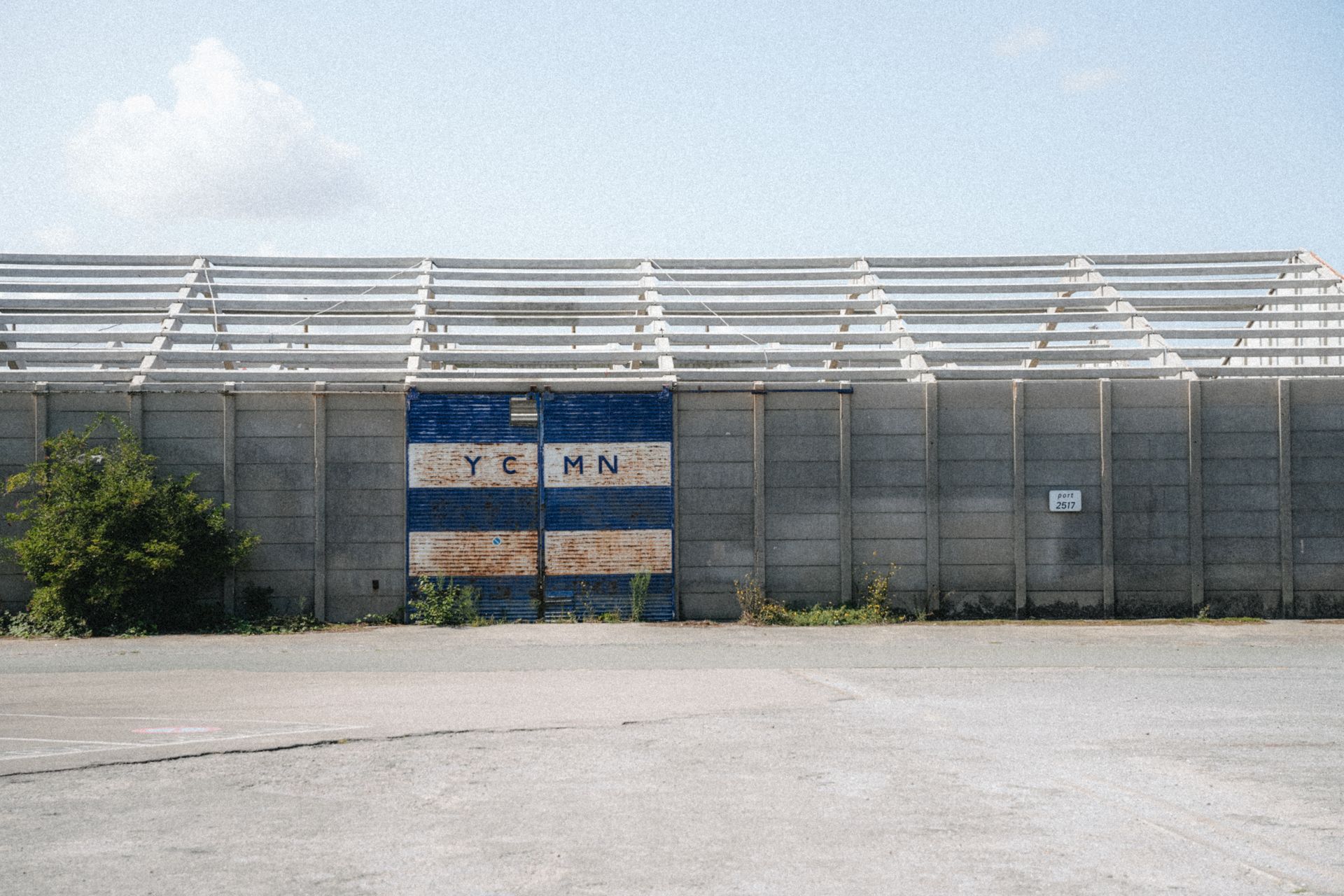 Exterior view of a warehouse in Dunkerque, France against a clear blue sky.