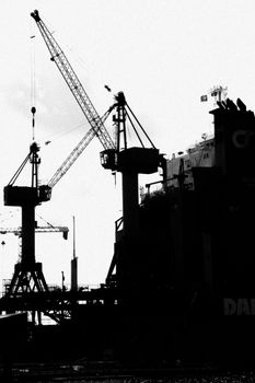 Black and white silhouette of cranes at a port in Dunkerque, France.