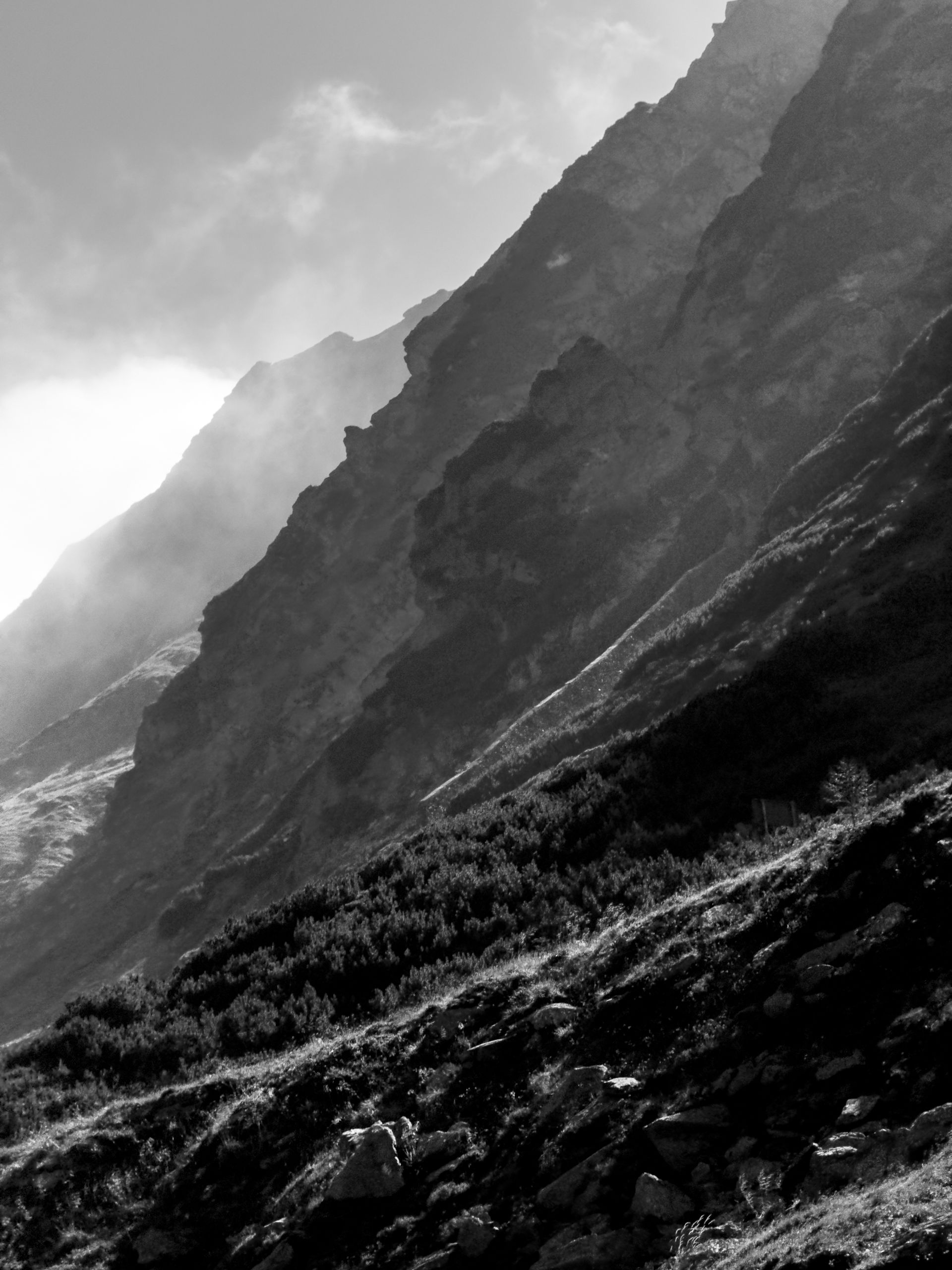 Layered mountain ridges fading into mist, black and white