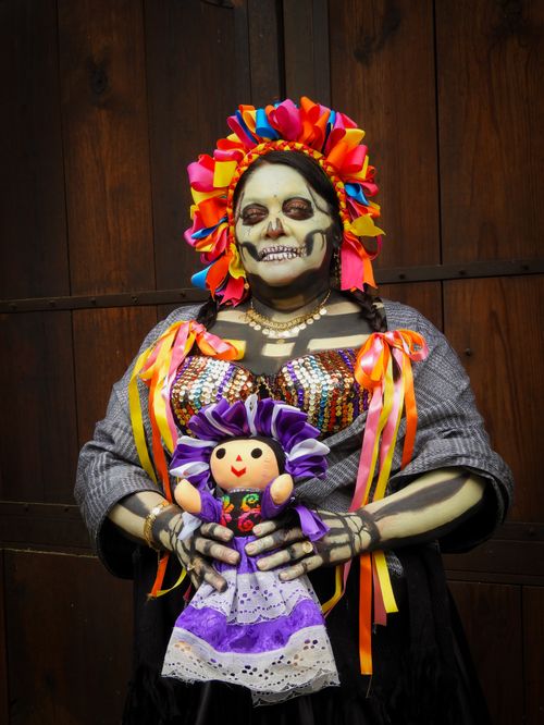 Free Vibrant Catrina makeup and costume with a doll in Ciudad de México for Día de los Muertos celebration. Stock Photo