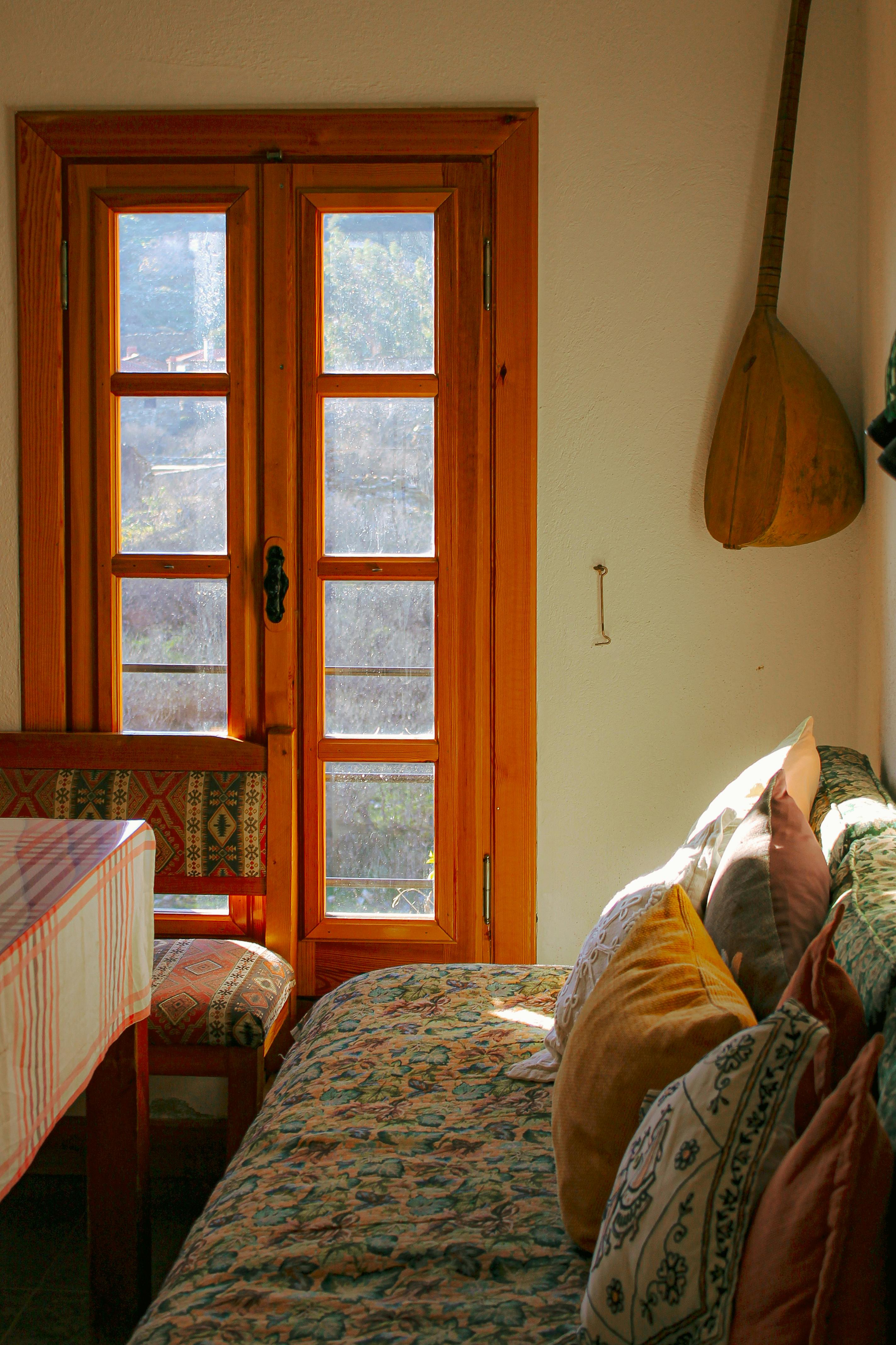 Sunlight streaming into a cozy room with wooden decor and colorful pillows.