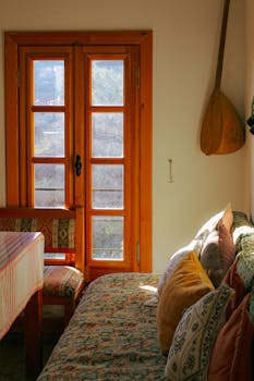 Sunlight streaming into a cozy room with wooden decor and colorful pillows.